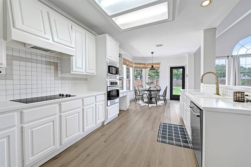 Beautiful kitchen featuring white cabinets, white countertops, and coordinating backsplash for a clean look.