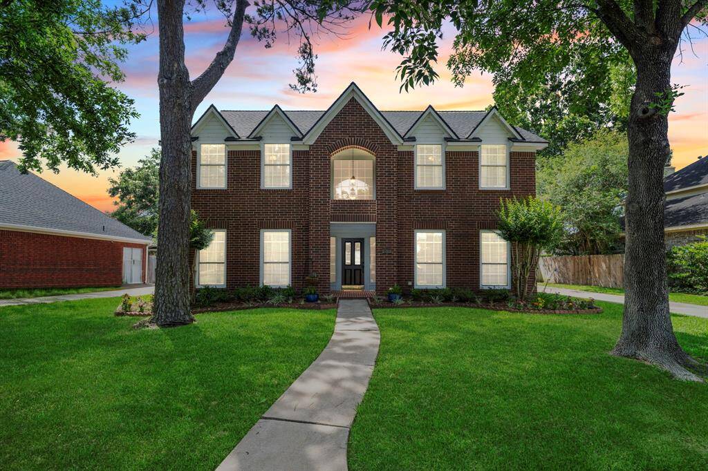 At twilight, the home glows with warmth and elegance, highlighting its classic design and inviting presence in the desirable Governors Place community.
