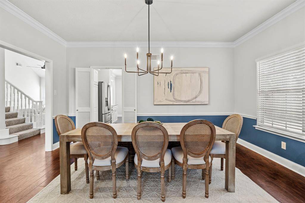 The formal dining room offers a bright and inviting space with crisp crown molding, a stylish two-tone wall treatment, and direct access to the kitchen for effortless entertaining.