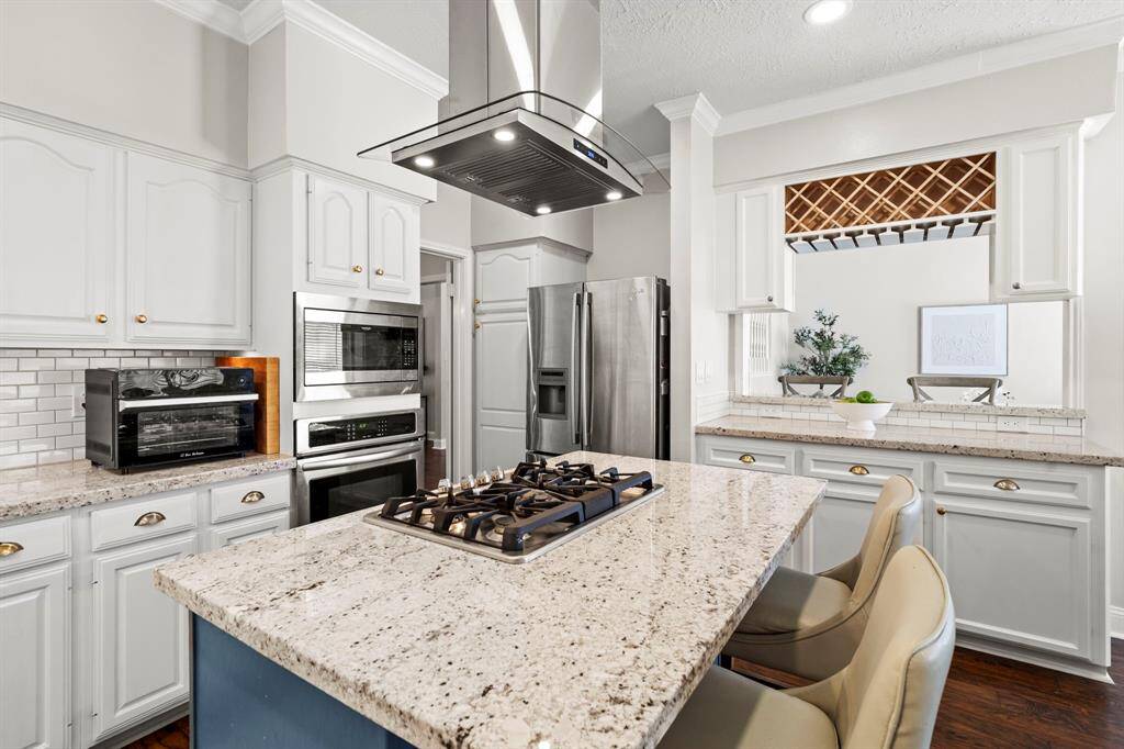 Additional built-in appliances and abundant cabinetry ensure that everything has its place in this well-equipped kitchen designed for daily use and special occasions.