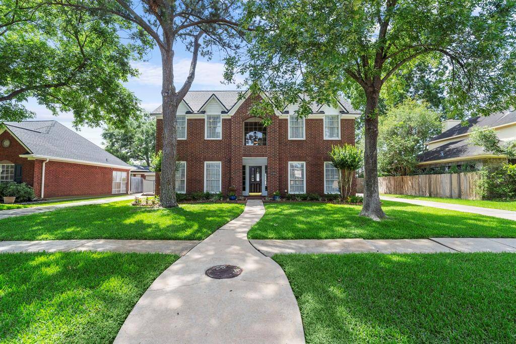 This stately Plantation-built home in Governors Place offers timeless curb appeal with a classic red brick façade, mature shade trees, and a beautifully manicured lawn.