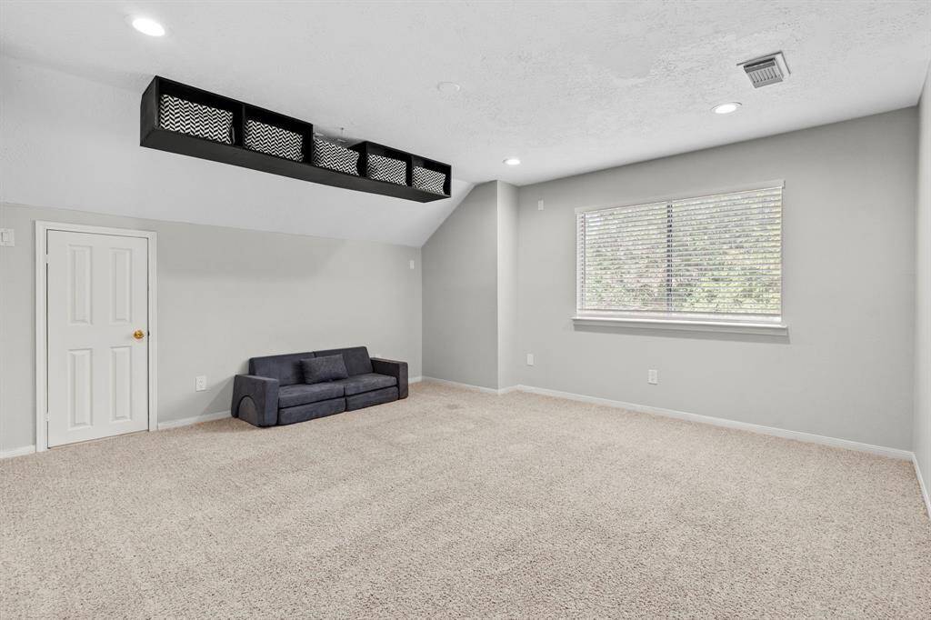 With vaulted ceilings, multiple windows for natural light, and versatile open space, this upstairs game room is ready for movie nights, play time, or your dream media setup.