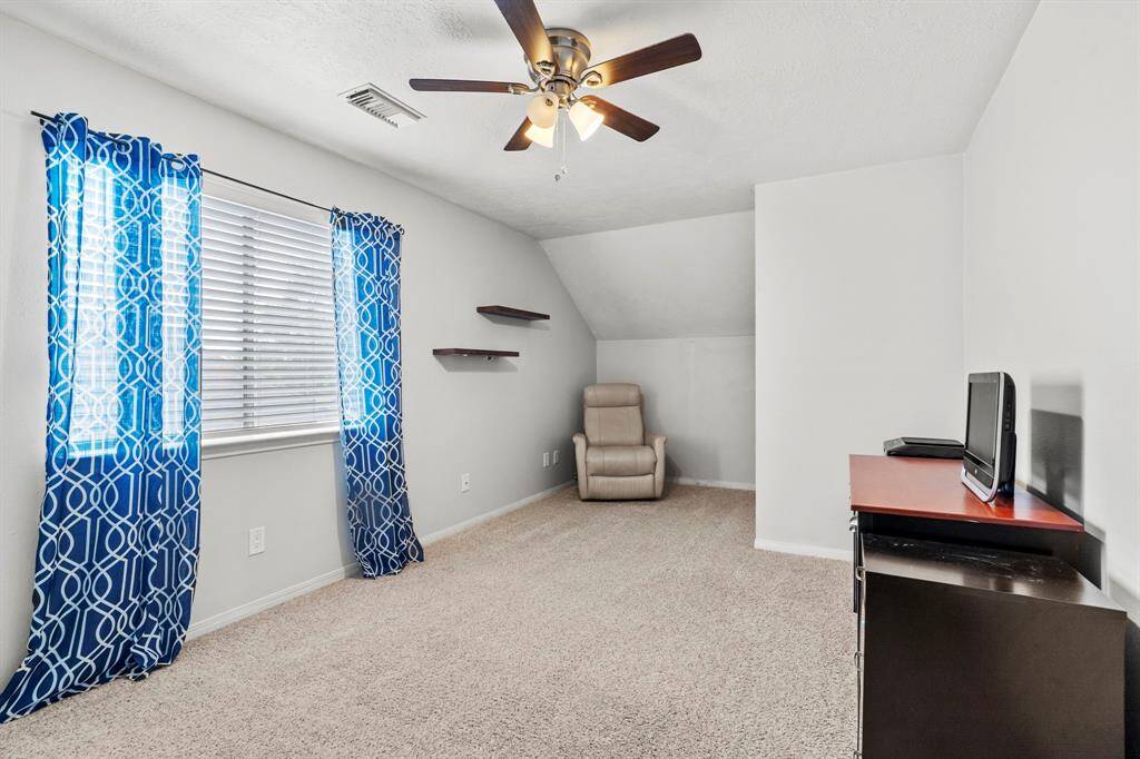 This upstairs guest bedroom offers cozy carpet, soft neutral walls, and a charming window nook—ideal for relaxing, studying, or streaming your favorite shows.
