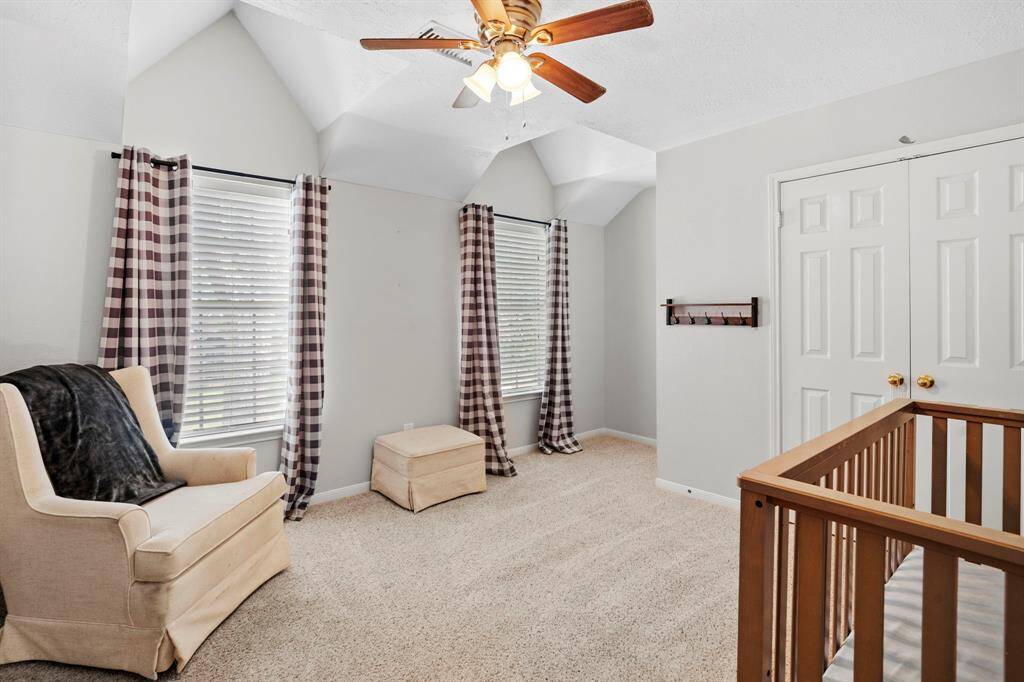 Featuring vaulted ceilings and generous closet space, this secondary bedroom is filled with natural light and flexibility for any setup.