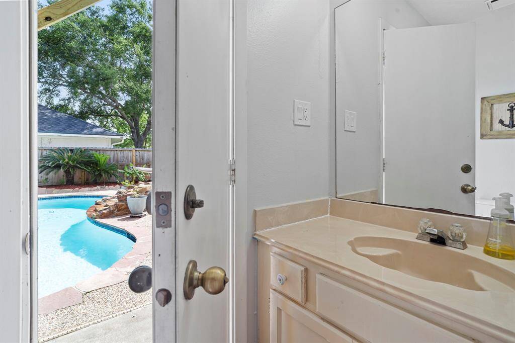 Conveniently located just off the pool area, this dedicated bathroom offers quick access for rinsing off and freshening up—no need to track water through the house!