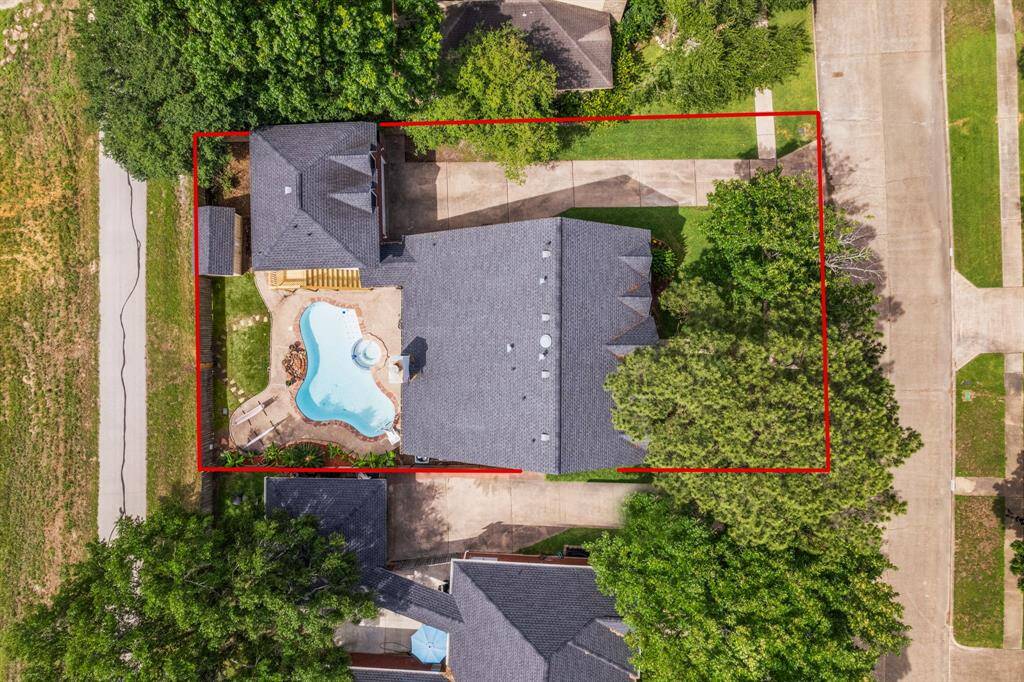 This overhead shot outlines the full property, highlighting the generous layout that includes a resort-style pool, detached garage apartment, and ample driveway space.