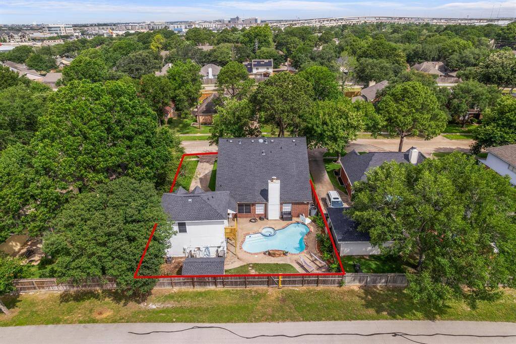 From the rear of the lot, you can see the entire fenced property, including the main home, garage apartment, and expansive backyard designed for entertaining and everyday enjoyment.
