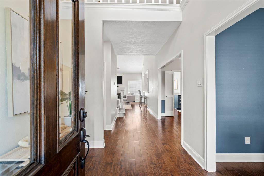 As you step inside, the foyer opens to a light-filled hallway with views into the main living spaces, offering a seamless connection to both the formal and casual areas of the home.