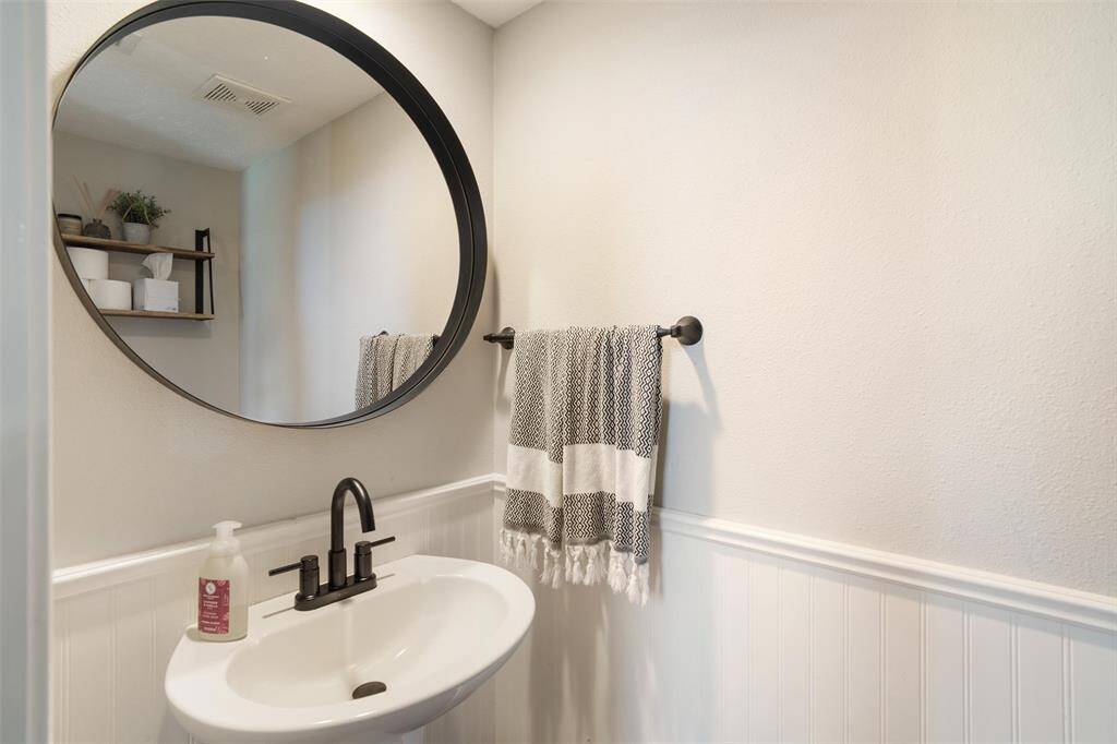 Half bath updated with beadboard and a framed mirror
