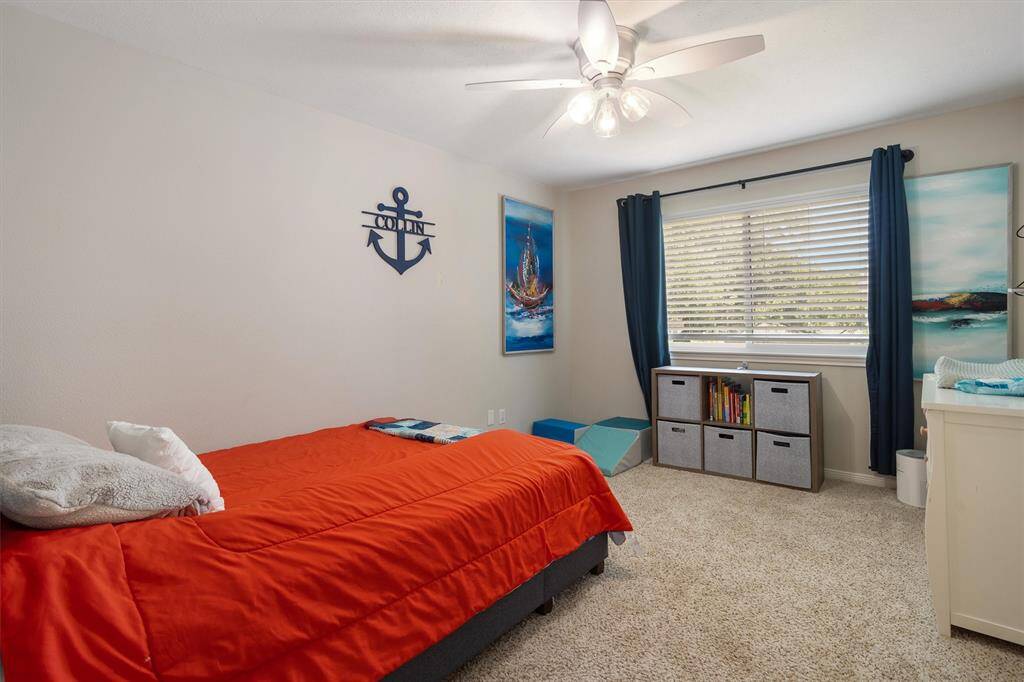 Third bedroom with ceiling fan and window overlooking the backyard.