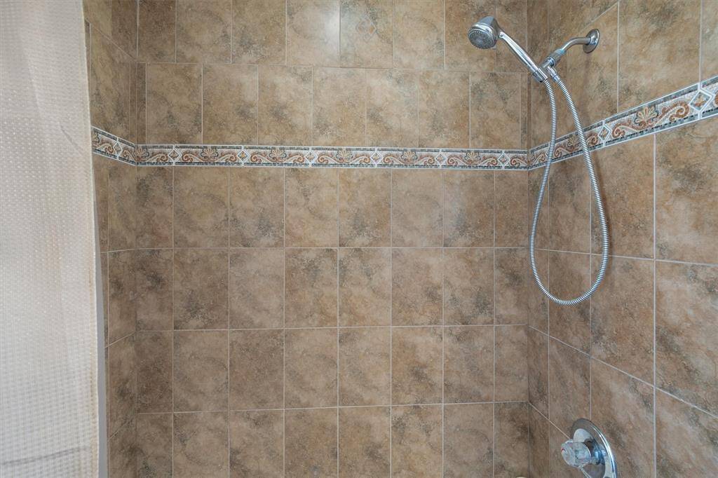 Fully tiled standalone shower located in the second full bath