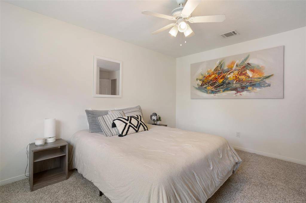Fourth bedroom with ceiling fan and window overlooking the backyard.