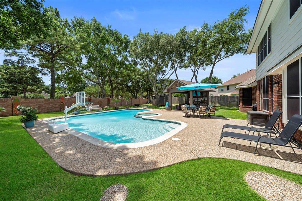 This Spectacular Large Pool has a basketball goal, diving board, a hot tub, and aroung the pool there is still plenty of space sundeck, lounging area, and a large outdoor table!!