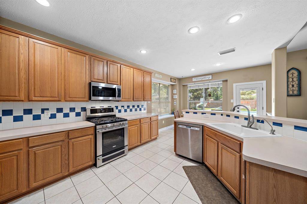 Kitchen overlooking the Living room and that gorgeous back yard. Lots of Counter space and an abundant amount of cabinets
