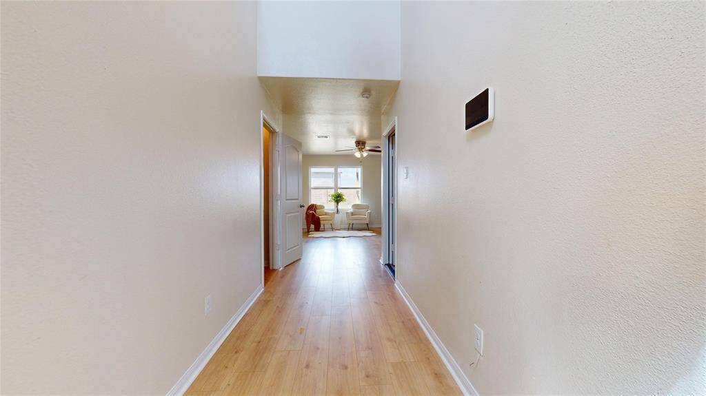 2429 Regatta Ln, Hallway onto the living area, wooden laminate flooring throughout. 1/2 restroom entry door and exit door to garage.