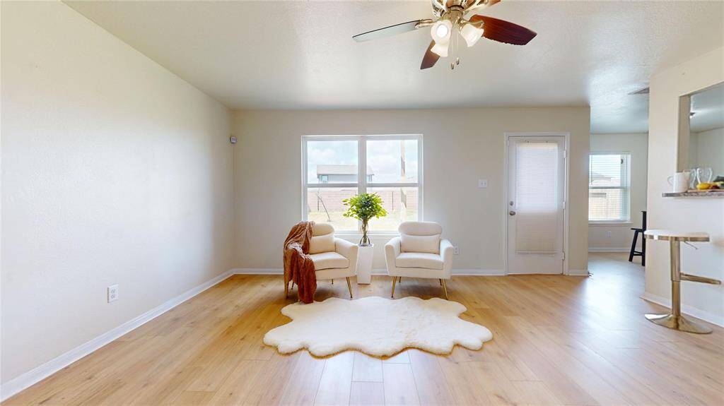 2429 Regatta Ln, Living room with large windows for great lighting, wooden laminate flooring, open to kitchen and dining area and back door to backyard with window.