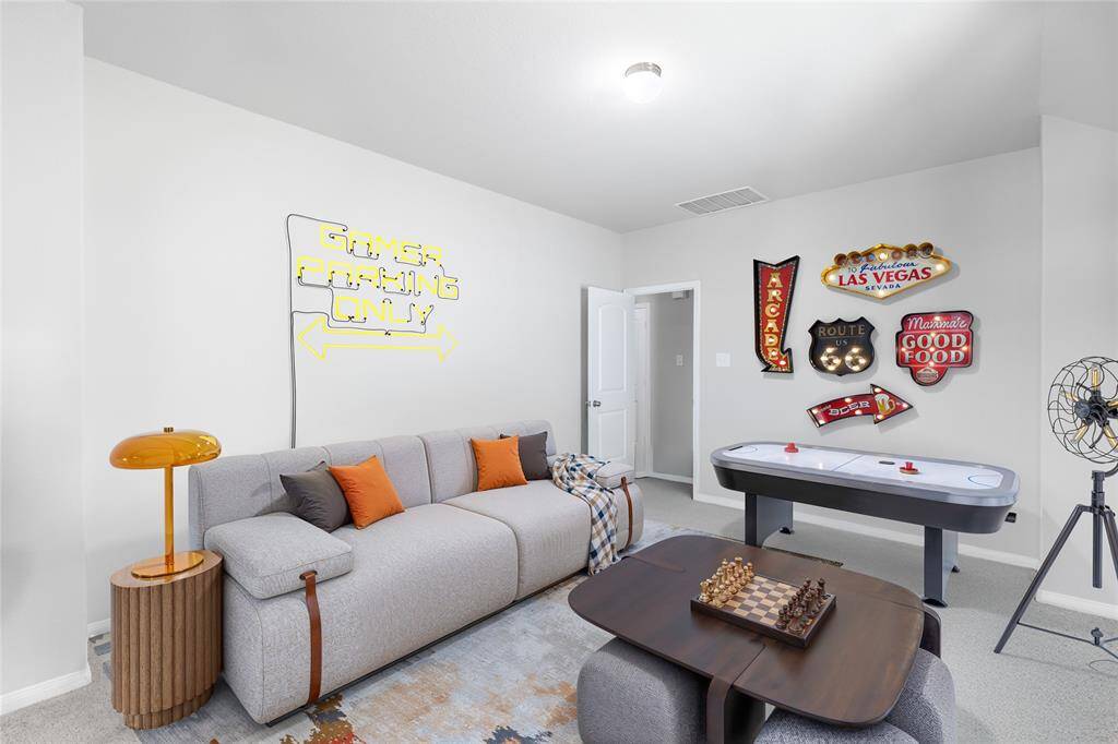 Digitally staged as a game room, this spacious upstairs area offers tremendous flexibility—ideal as a fun-filled retreat, media room, or even a generously sized primary suite. While the current photo showcases a bright, playful setup, please note that the actual room has standard lighting with a softer, yellow tone.