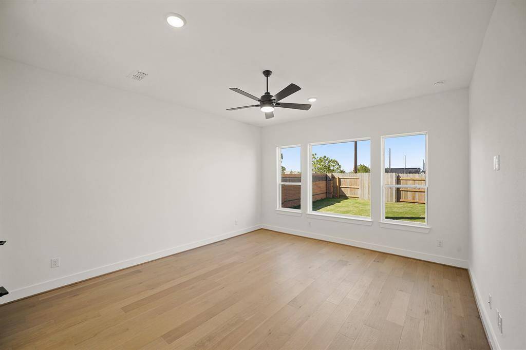 The primary bedroom is spacious and serene, with soft natural light streaming through large windows, creating a calm, inviting atmosphere perfect for relaxation.