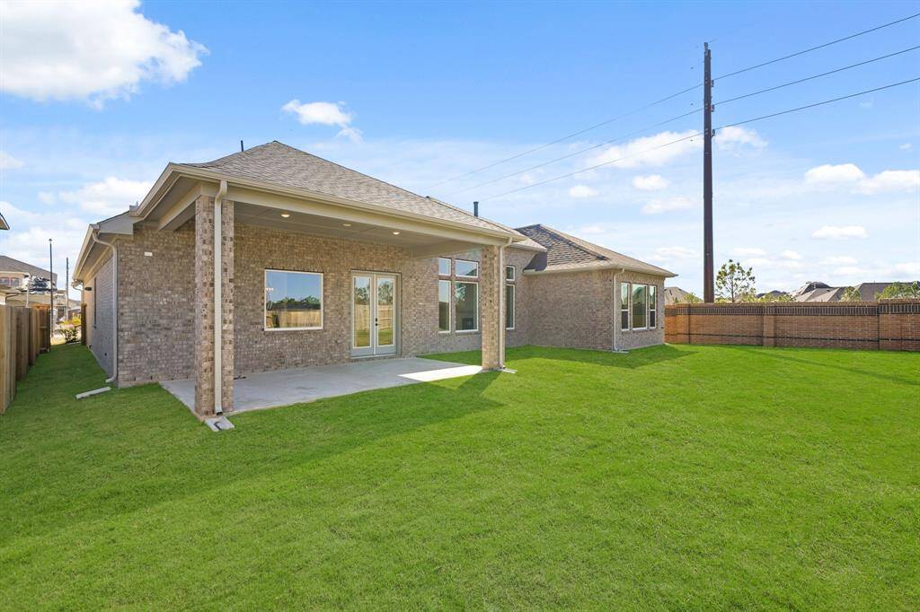 The empty backyard is a wide, open space with a well-kept lawn, waiting to be shaped into a personalized outdoor retreat.