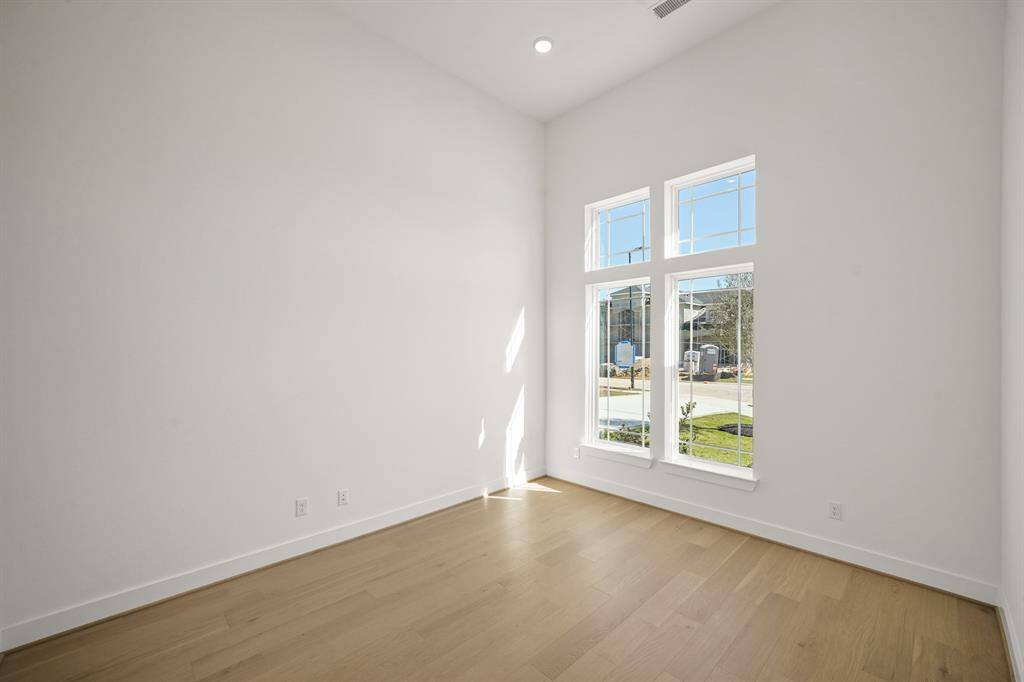 The study is quiet and uncluttered, with a large desk, built-in shelves, and plenty of natural light, providing an ideal space for focus and productivity.