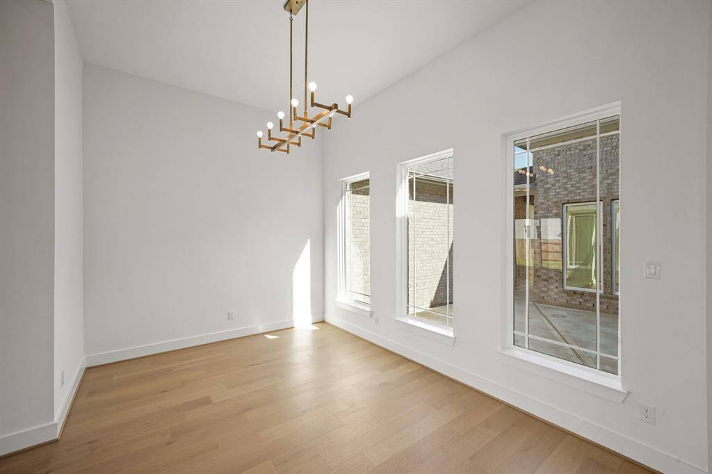 A elegant dining room with a sparkling chandelier, offering a scenic view of the serene courtyard.