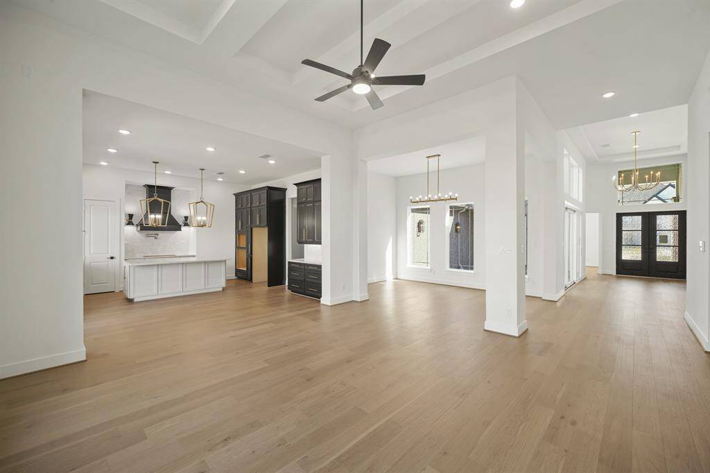 The open space features a large island at the center, with high ceilings that amplify the airy, expansive feel of the room, creating a bright and inviting atmosphere.