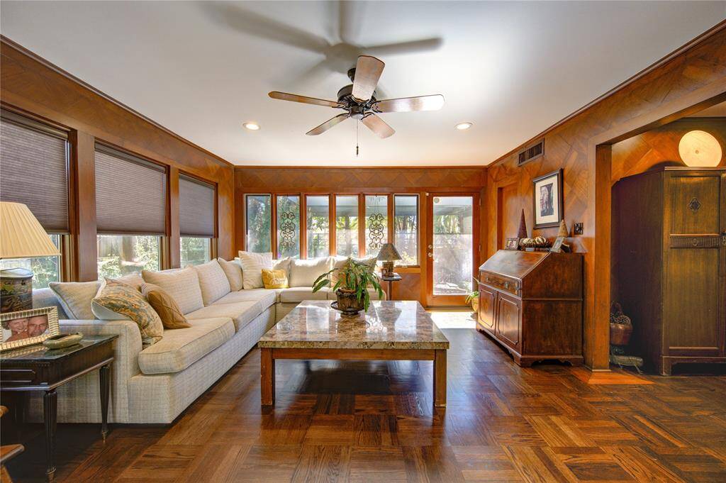 The living room opens up beautifully to the sunroom, still honoring the original stye, character and details of the 1950s offering additional lighting from the south and east into the home. The door on the right opens to the front courtyard Zen space.
