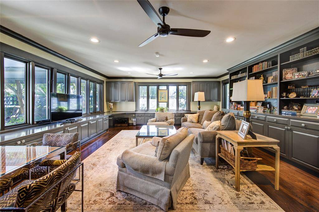 Stunning, sun-lit den remodeled with comfort and convenience in mind. Thoughtfully laid out with upper and lower cabinets, generous workspace, two cutouts for desk space and a wet bar on the opposite side of the room for when the work day is done.