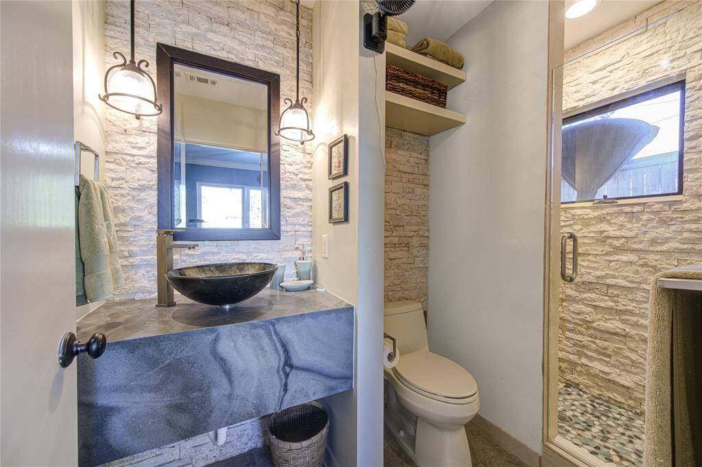 Casita bathroom is simple and stylish with stacked stone detailing, step in shower with river rock flooring and lovely light from the west.