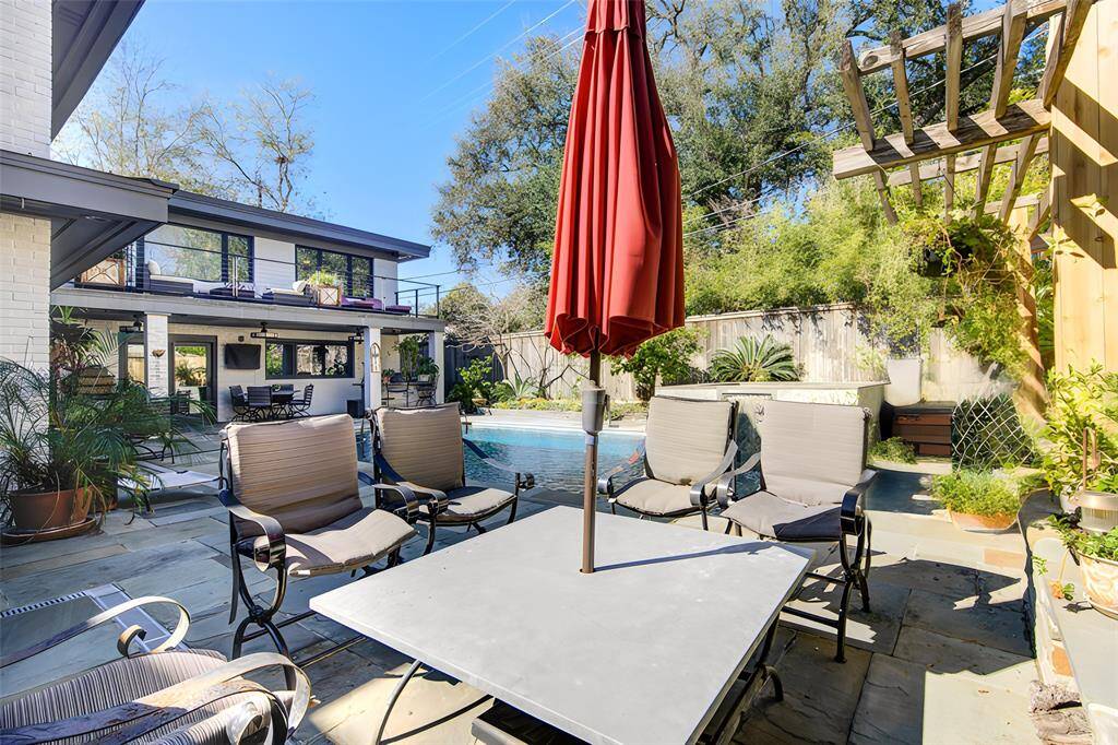 One of multiple seating areas in and around the serene pool that comes with solar heater cover.  Custom designed and built fireplace is wood-burning and has a raised flower bed.