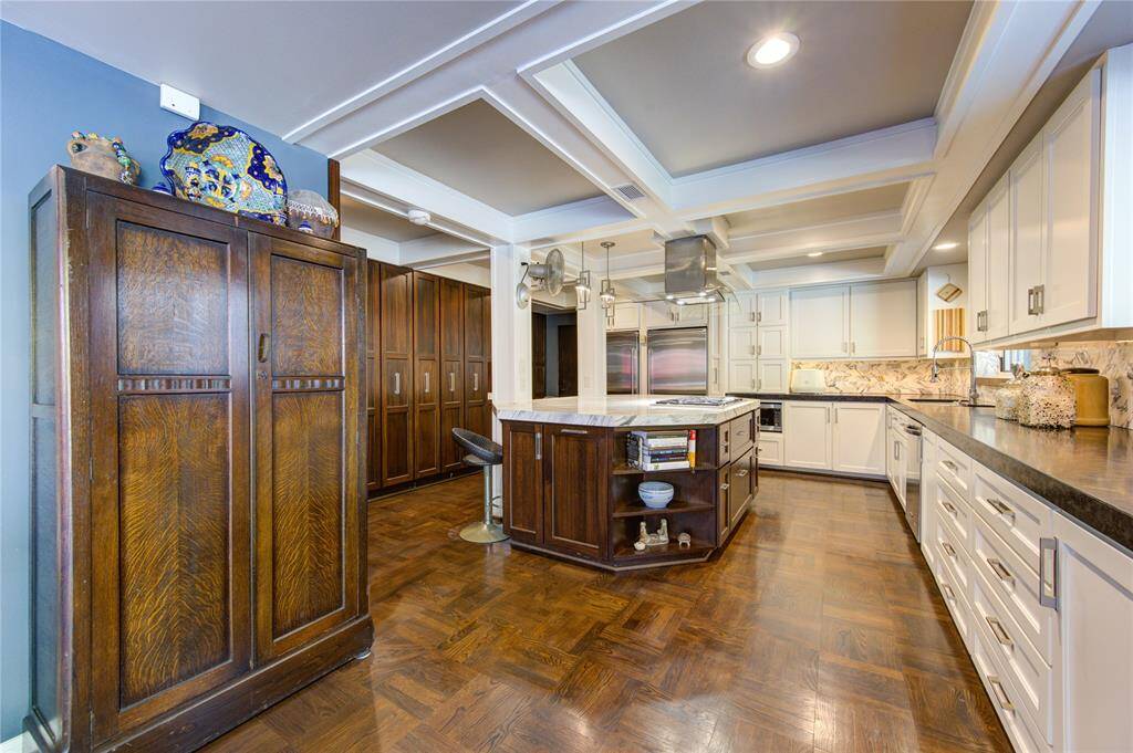 Additional upgrades include stylish pull out pantry cabinets, complimentary base cabinets and a modern take on the coffered ceiling.