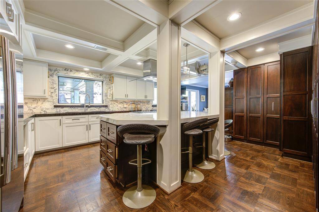 Convenient pull up seating for easy service or a sous chef to comfortably help out of the way. Beautiful parquet flooring anchors the entire space.