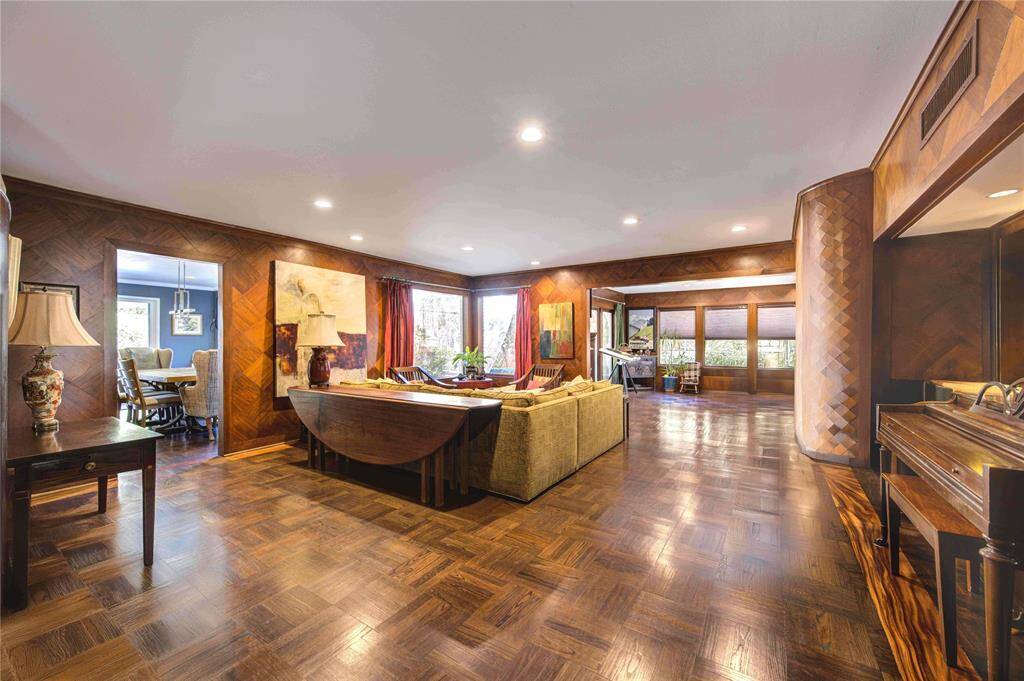 Living room retains much of the original charm and detail from 1956 with parquette flooring, curved wall details, accent mirror wall and numerous windows allowing for an effortless blend between the interiors and outdoors.