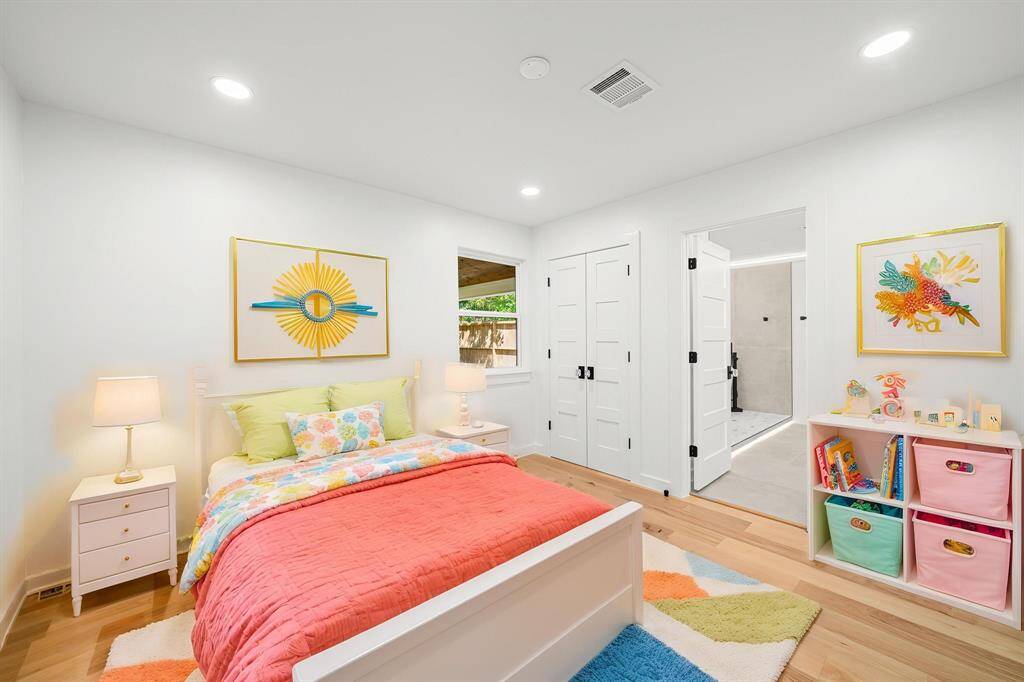 A spacious bedroom with rich wood flooring, stunning new windows, and elegant solid wood doors offers a refined retreat.