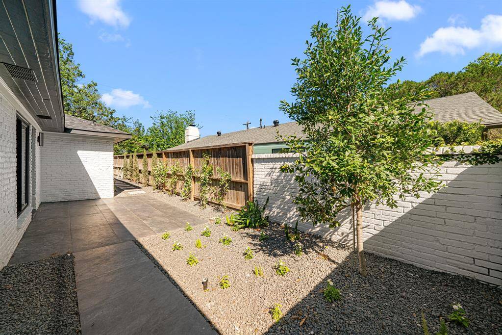 Outdoor elegance perfected – Impeccable landscaping, a sophisticated porcelain-tile patio, and a high-quality fence create a seamless blend of beauty and privacy.
