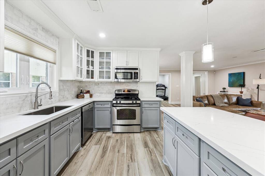 Bright and inviting kitchen featuring a marble backsplash, undermount sink, and a window for natural light.