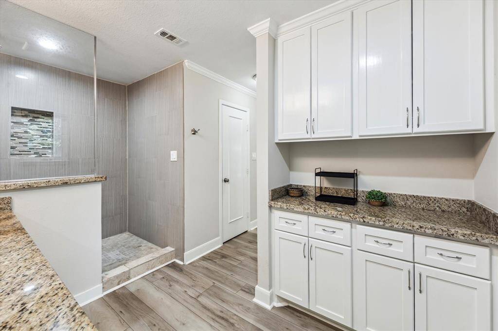 Ample storage and additional counter space makes this primary bathroom both functional and elegant.