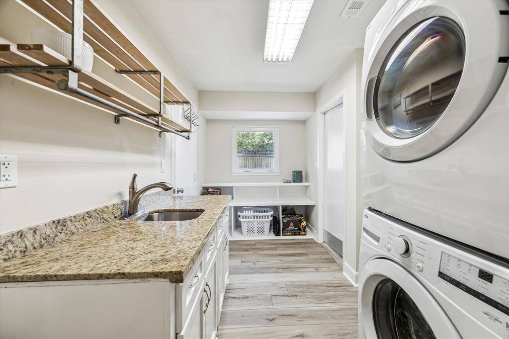 Enjoy a versatile laundry area with ample storage and a sink, seamlessly connected to the attached garage, perfect for use as a convenient mudroom.