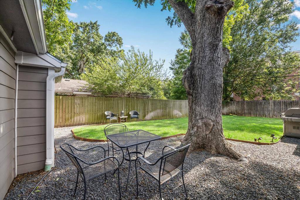 Serene backyard oasis with majestic, mature tree.