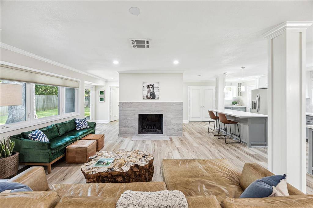 This bright living room features a stunning fireplace and elegant luxury vinyl flooring throughout.
