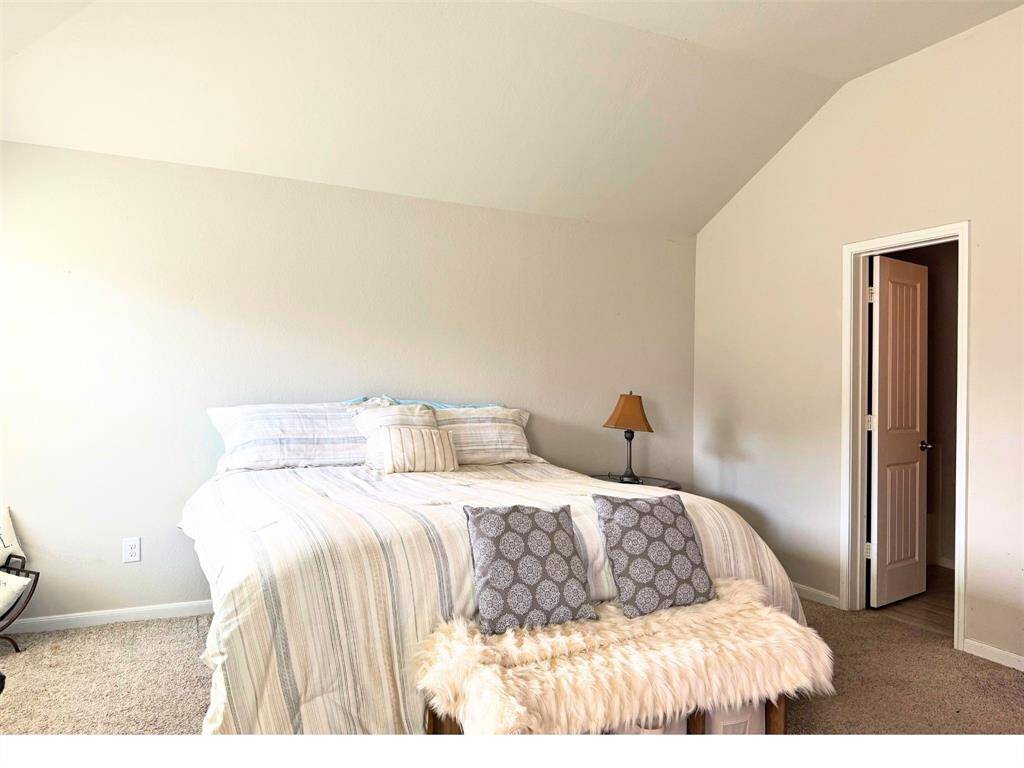 Primary bedroom with high ceilings leading to primary bathroom