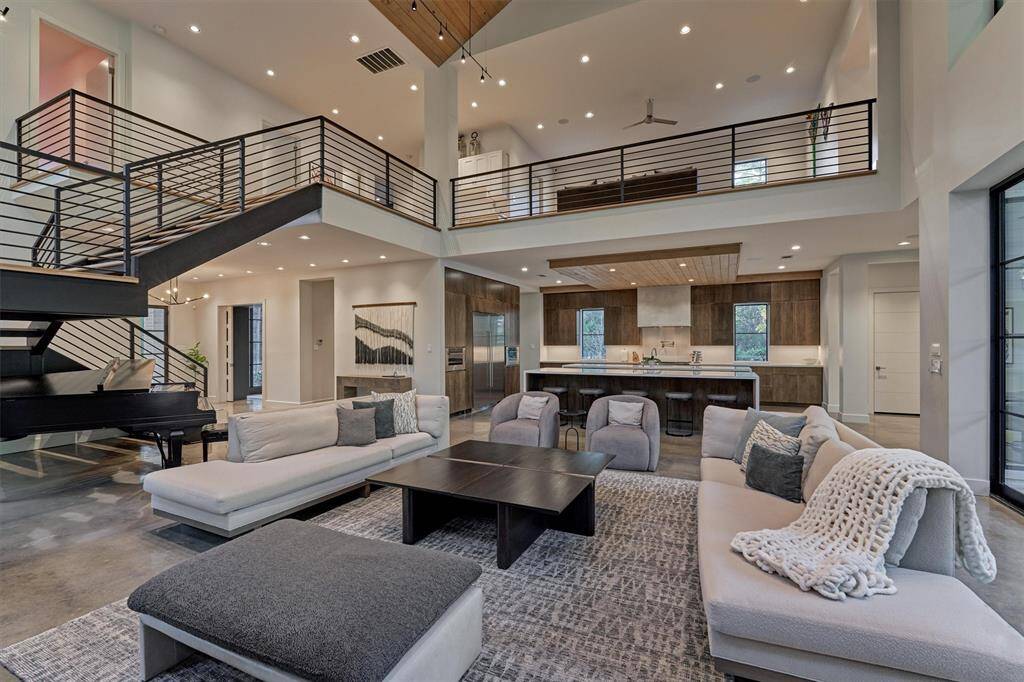 Thoughtfully designed living space with curated lighting from Visual Comfort and stained concrete floors