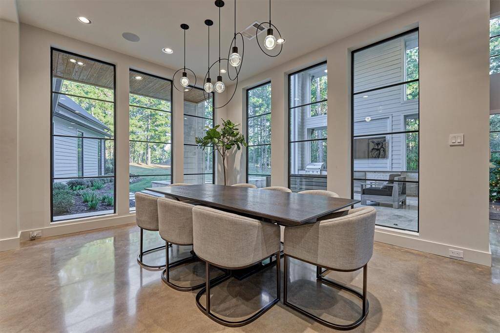 Elegant dining space featuring a Visual Comfort chandelier and open flow to the kitchen and living room