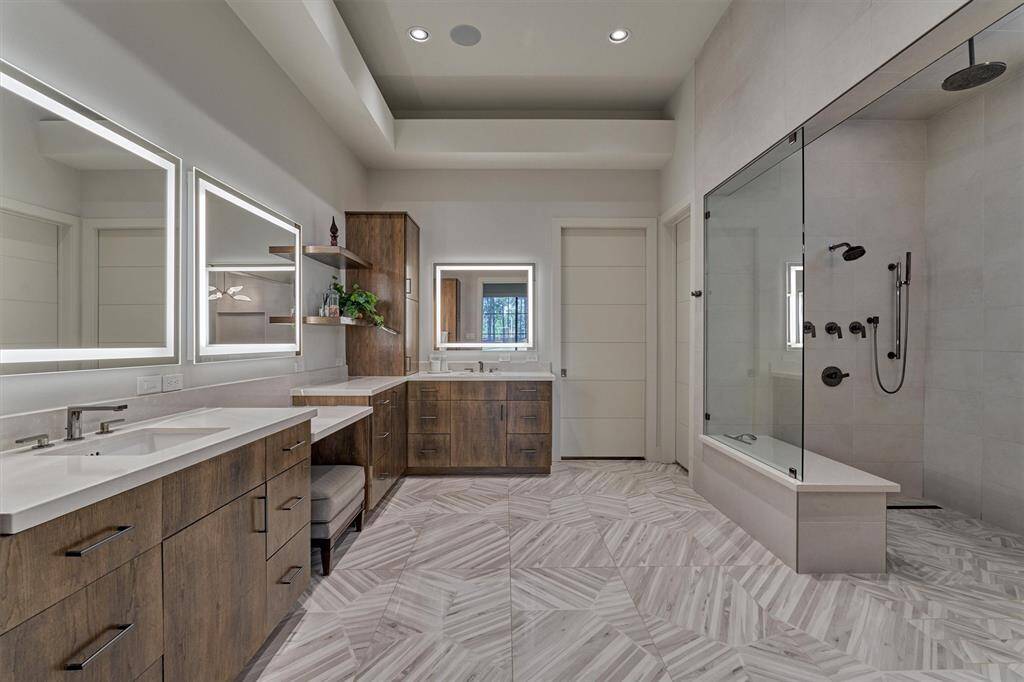 Spa-like design with flat-panel white oak cabinetry and premium lighting from Visual Comfort. Convenient laundry chute connects the master closet directly to the utility room