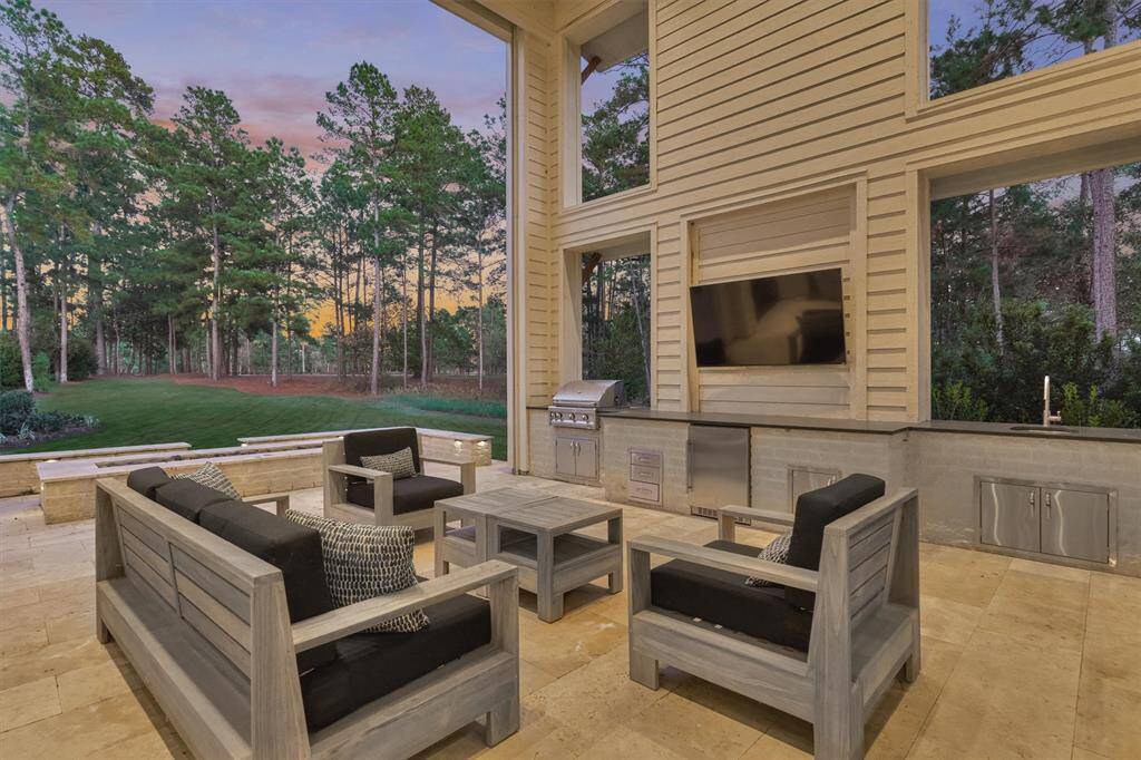 Fully equipped outdoor kitchen with Coyote grill, sink, mini-fridge, and generous prep space