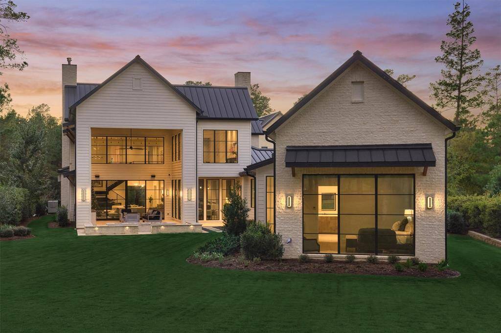 The rear elevation glows at dusk, showcasing outdoor entertaining areas and clean modern lines