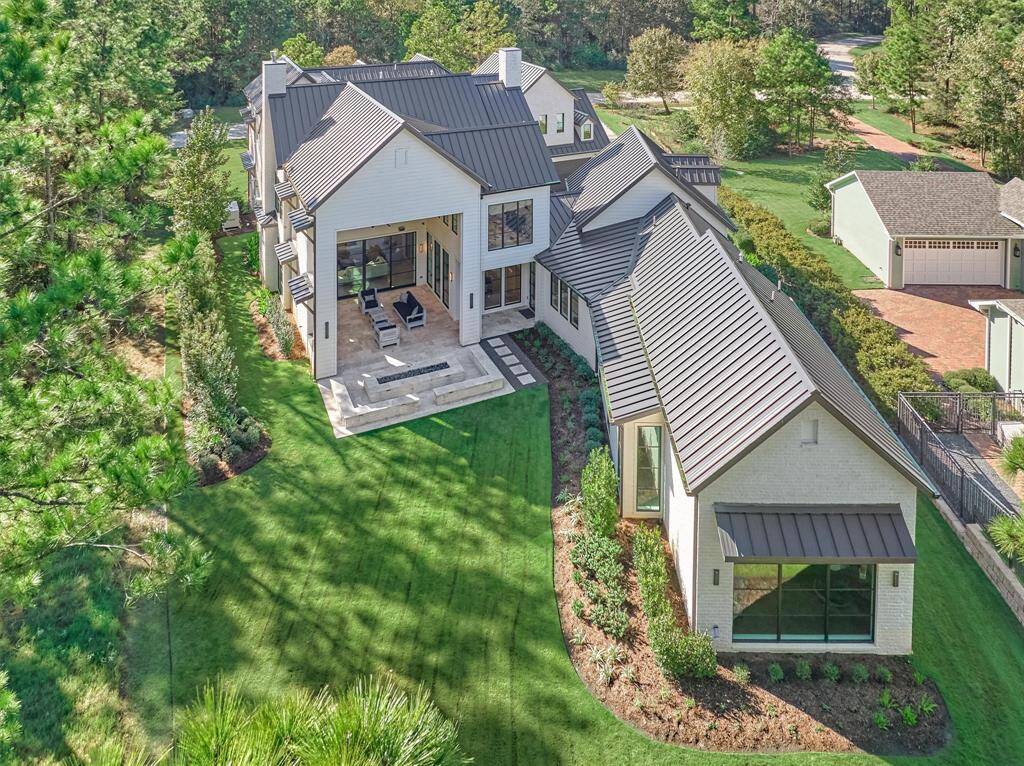 Stunning aerial shot reveals expansive outdoor living areas, lush landscaping, and direct golf course access