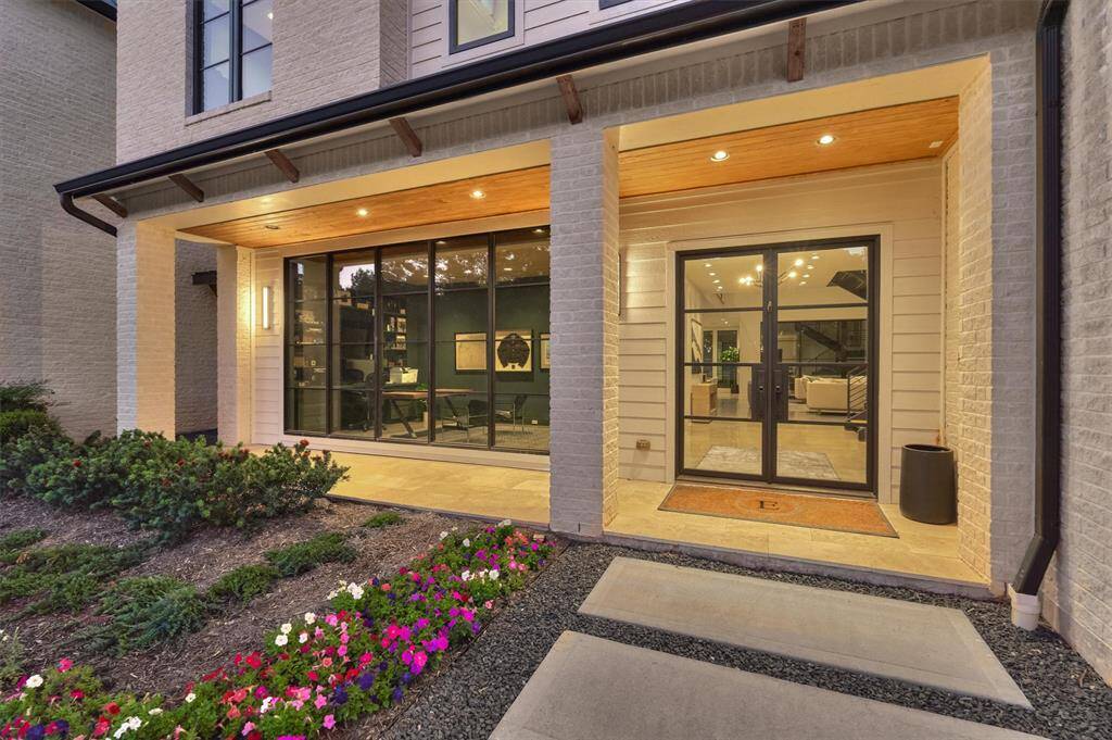 Covered front entry with modern wood and glass door creates a warm and stylish first impression