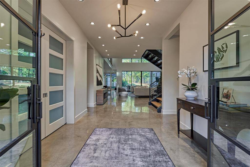 Statement entry with wide doors opening to reveal modern overhead lighting and stunning architectural details