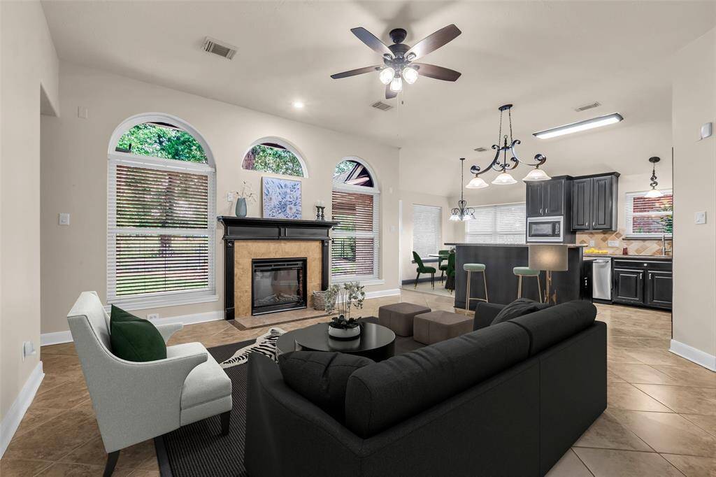 Light-filled great room with wall of windows overlooking the backyard. Virtually staged.